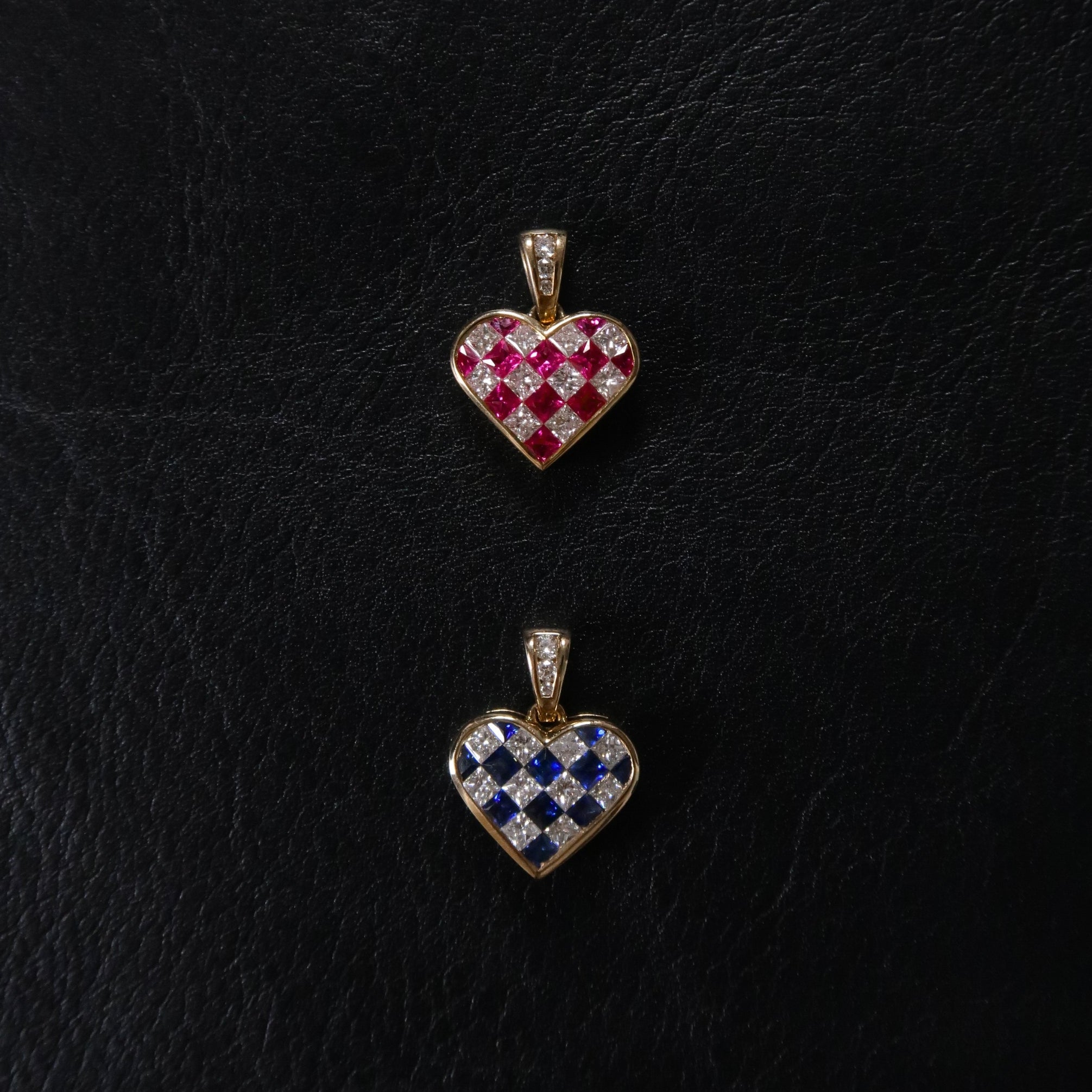 Two heart-shaped pendants on a black textured background